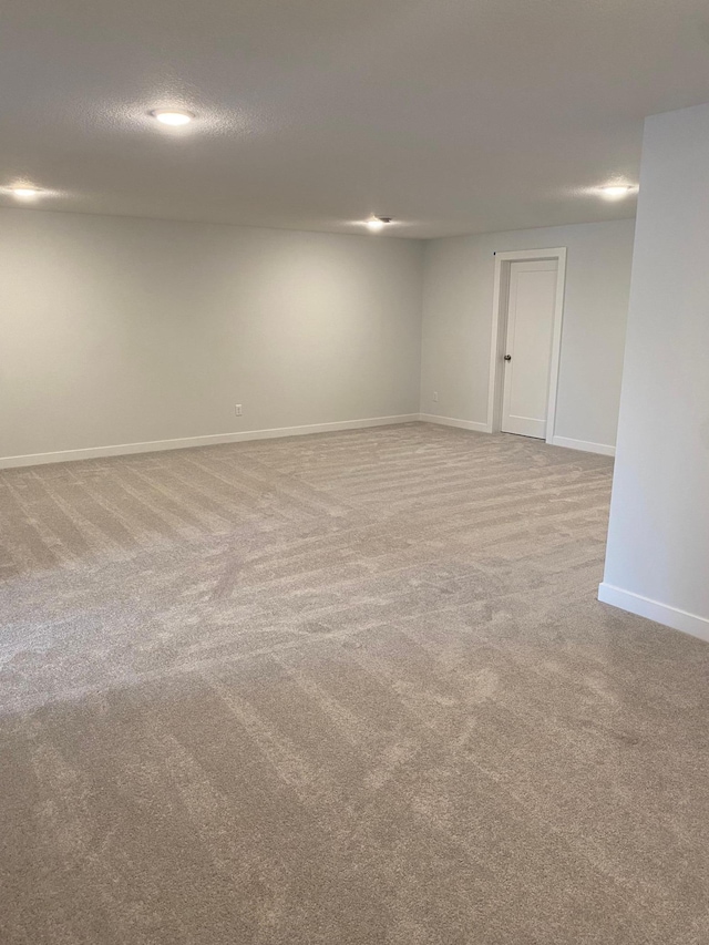 unfurnished room with a textured ceiling and light carpet