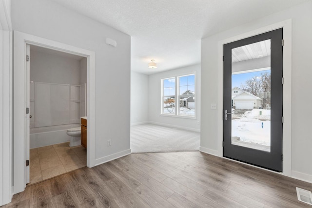 entrance foyer with a textured ceiling and light wood-type flooring