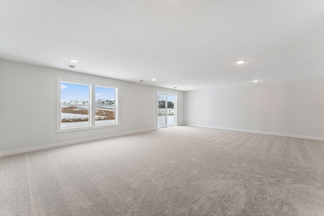 carpeted empty room featuring a textured ceiling