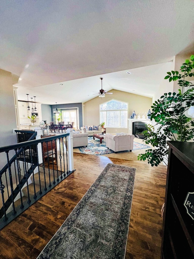 living room featuring ceiling fan, hardwood / wood-style floors, and vaulted ceiling