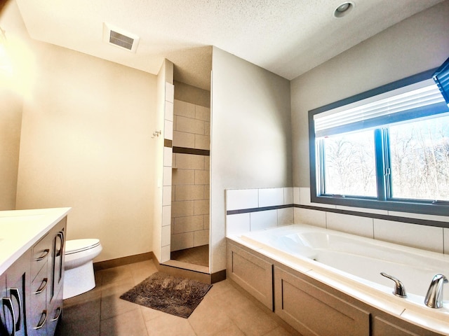 full bathroom featuring a textured ceiling, tile patterned floors, vanity, toilet, and separate shower and tub