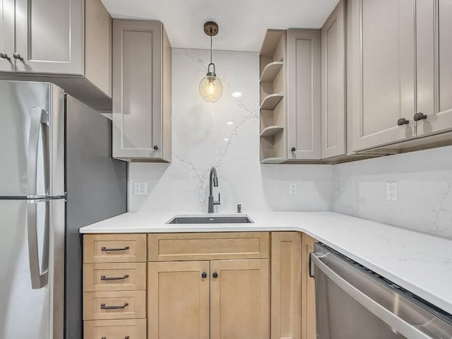 kitchen featuring stainless steel appliances, decorative light fixtures, light brown cabinetry, and sink