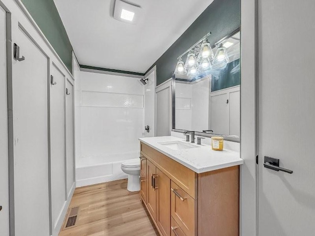 full bathroom featuring shower / tub combination, vanity, hardwood / wood-style floors, and toilet