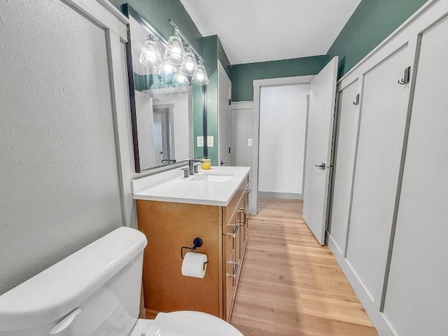 bathroom featuring vanity, wood-type flooring, and toilet