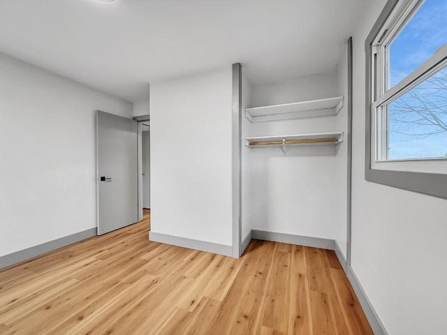 unfurnished bedroom with a closet and light wood-type flooring