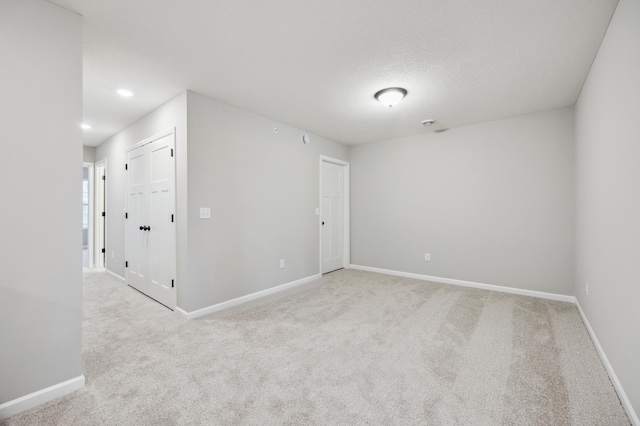 carpeted spare room with a textured ceiling