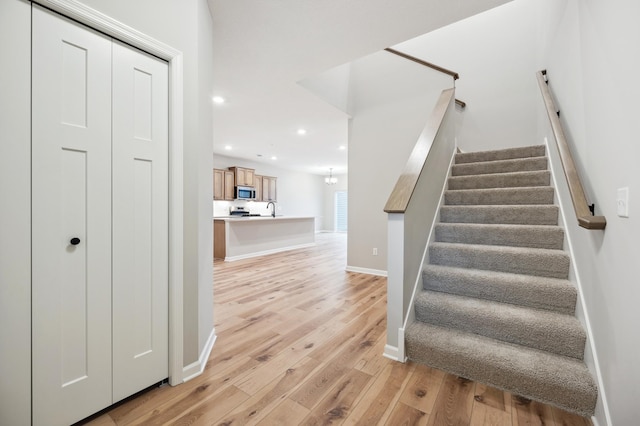 stairs with sink and hardwood / wood-style floors