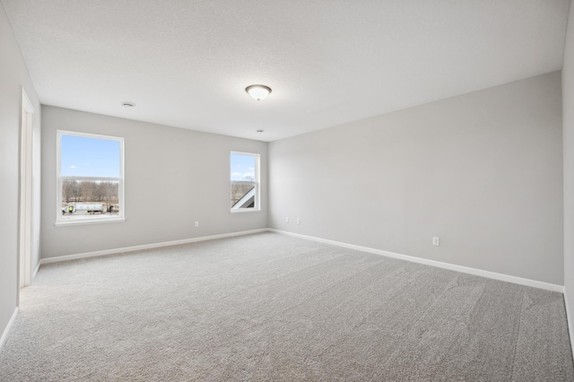 carpeted spare room featuring a textured ceiling