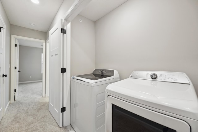 laundry room with light colored carpet and washing machine and clothes dryer