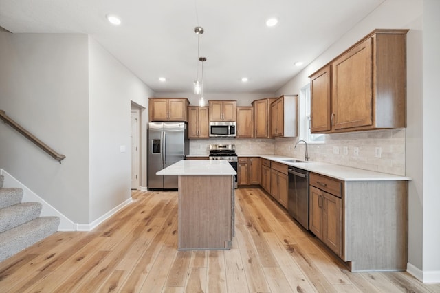 kitchen featuring appliances with stainless steel finishes, pendant lighting, tasteful backsplash, sink, and a center island