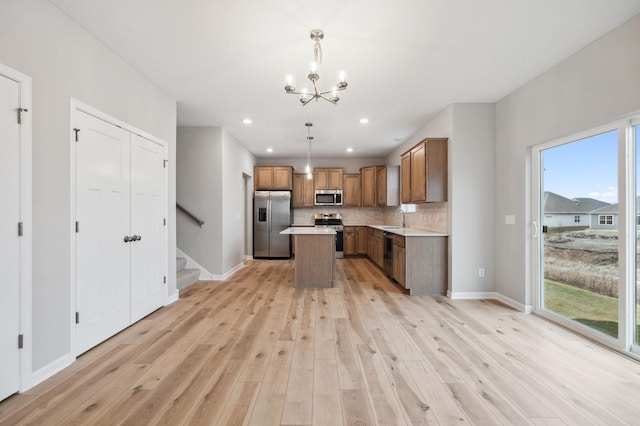 kitchen featuring sink, hanging light fixtures, a center island, light hardwood / wood-style floors, and stainless steel appliances