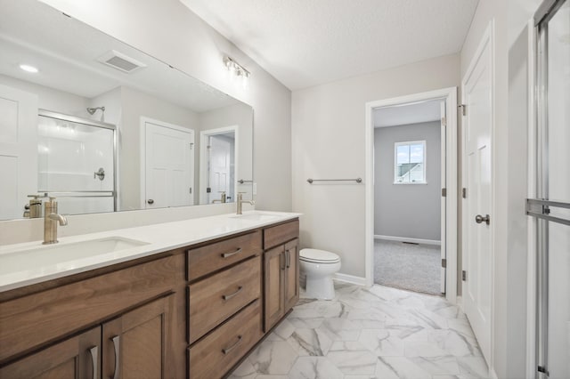 bathroom with vanity, a shower with door, toilet, and a textured ceiling