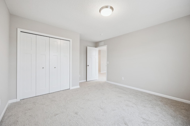 unfurnished bedroom featuring carpet floors and a closet