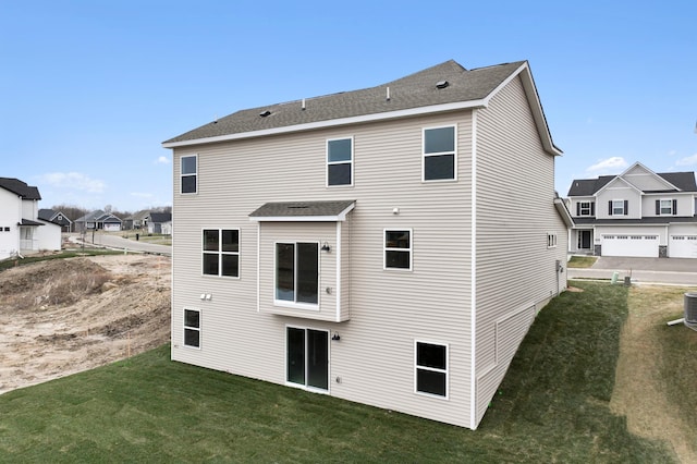 rear view of property featuring a lawn