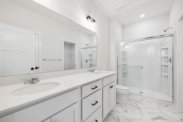 bathroom featuring double vanity, a shower stall, marble finish floor, and a sink