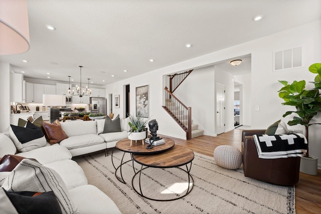 living room featuring a notable chandelier and light hardwood / wood-style flooring