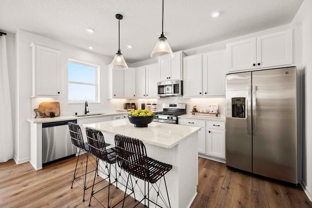 kitchen featuring stainless steel appliances, a center island, and white cabinets