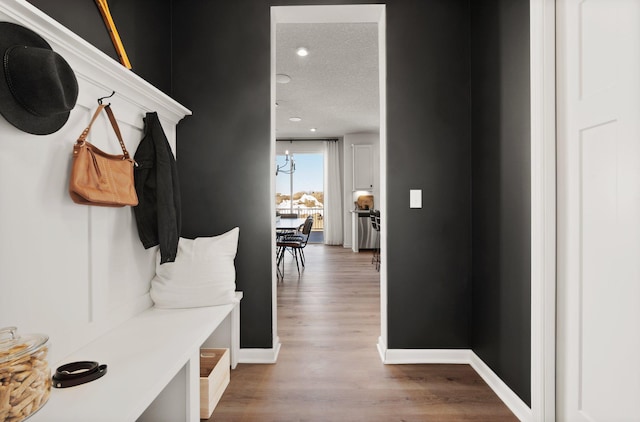 mudroom with a textured ceiling and light hardwood / wood-style flooring