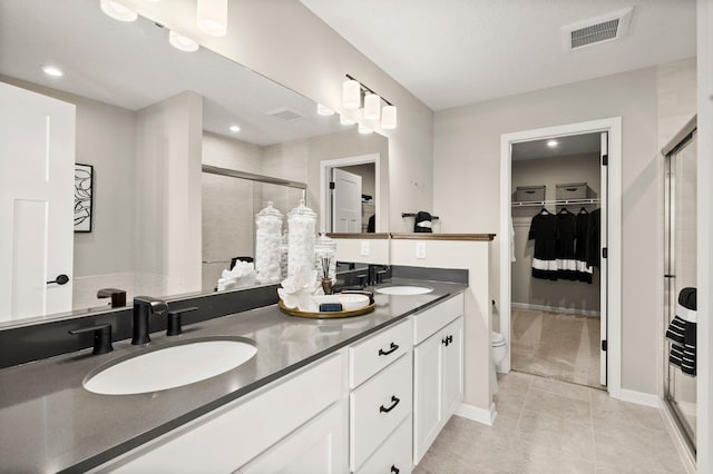 bathroom featuring vanity, toilet, an enclosed shower, and tile patterned flooring