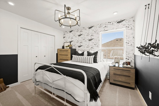 carpeted bedroom featuring a notable chandelier and a closet