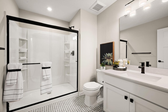 bathroom with a shower with door, vanity, and toilet