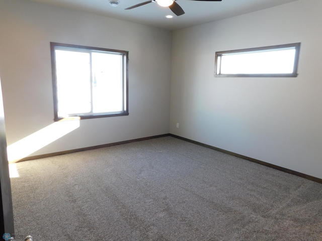 carpeted spare room with ceiling fan