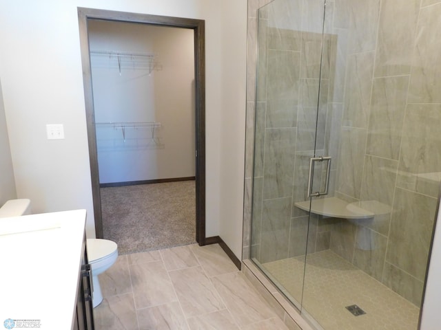 bathroom with vanity, toilet, and a shower with shower door