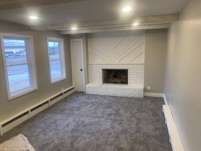 unfurnished living room featuring dark colored carpet, a brick fireplace, and baseboard heating