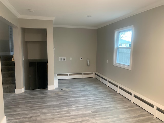 empty room with crown molding and light hardwood / wood-style flooring