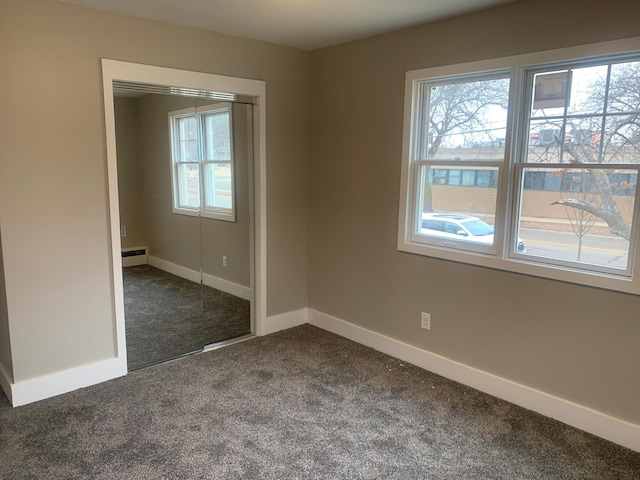 carpeted empty room with baseboard heating