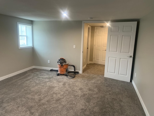 spare room featuring dark colored carpet