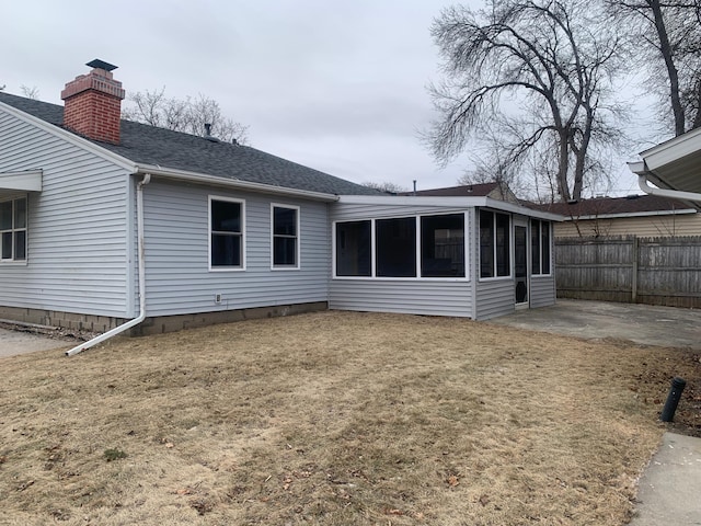 back of property featuring a patio, a sunroom, and a lawn