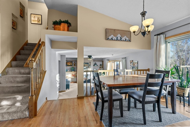 dining room with plenty of natural light, ceiling fan with notable chandelier, a textured ceiling, and light wood-type flooring