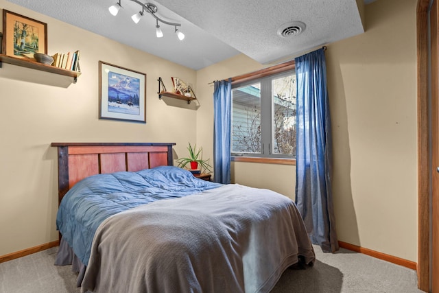 bedroom with carpet floors and a textured ceiling