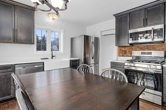 interior space featuring sink, stainless steel appliances, tasteful backsplash, dark brown cabinetry, and dark hardwood / wood-style flooring