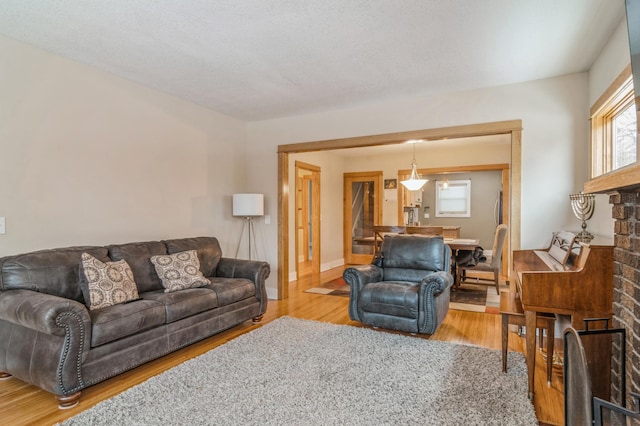 living room with a fireplace, light hardwood / wood-style floors, and a textured ceiling