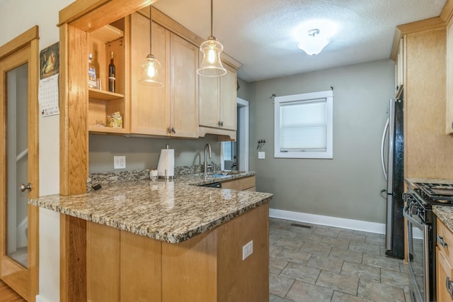 kitchen featuring stone counters, decorative light fixtures, stainless steel fridge, kitchen peninsula, and black gas range