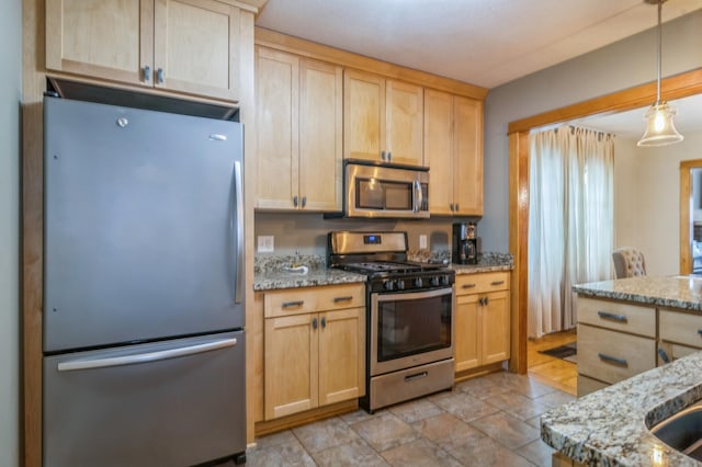 kitchen featuring light stone countertops, appliances with stainless steel finishes, pendant lighting, and light brown cabinetry