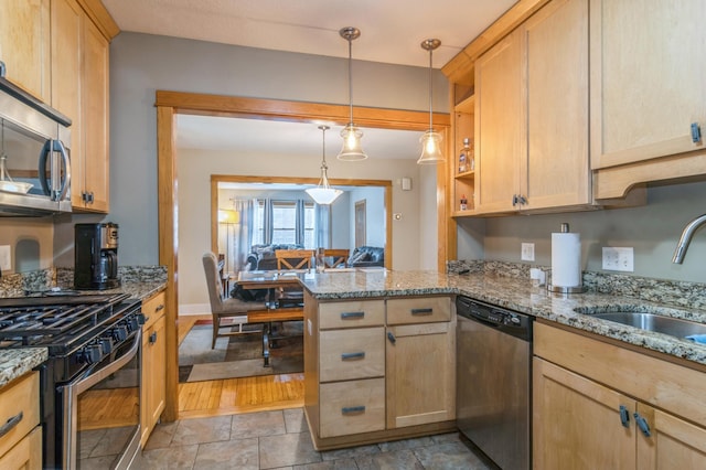 kitchen featuring sink, decorative light fixtures, appliances with stainless steel finishes, kitchen peninsula, and light stone countertops