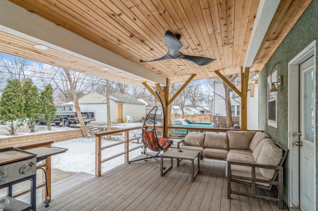 snow covered deck featuring an outdoor hangout area, an outdoor structure, and ceiling fan