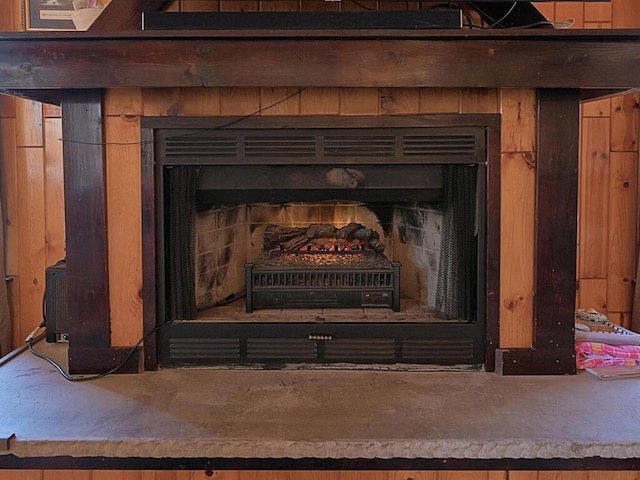 details featuring wood walls and a fireplace