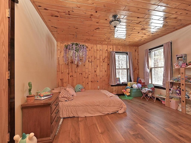 bedroom with light wood-type flooring, wood ceiling, and wood walls