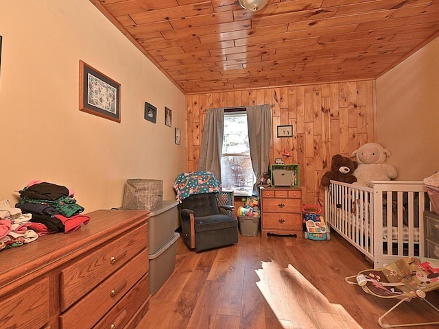 bedroom with wooden walls, wood ceiling, wood finished floors, and vaulted ceiling