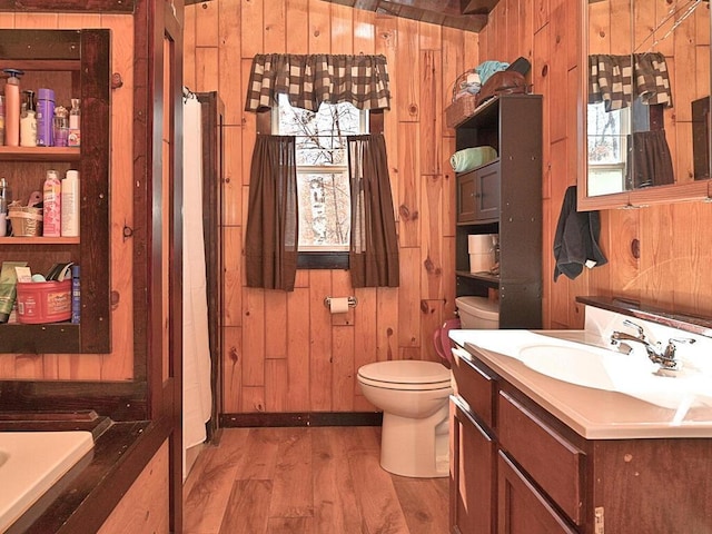 full bathroom featuring wood walls, toilet, a shower with curtain, wood finished floors, and vanity