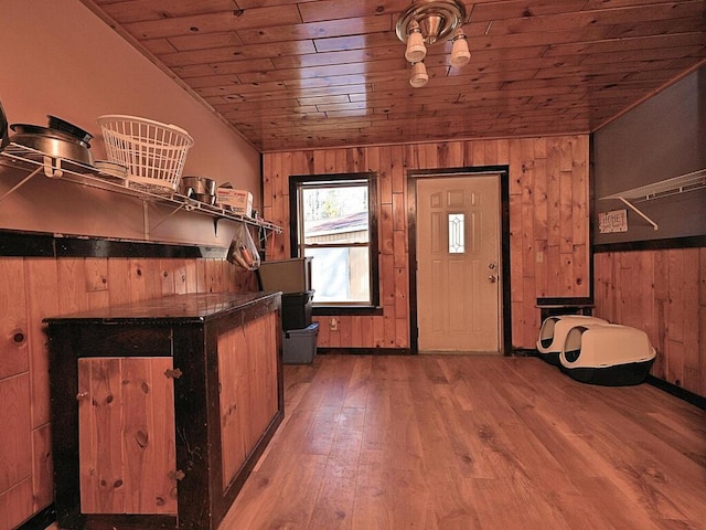 foyer entrance with lofted ceiling, wooden ceiling, wood finished floors, and wood walls