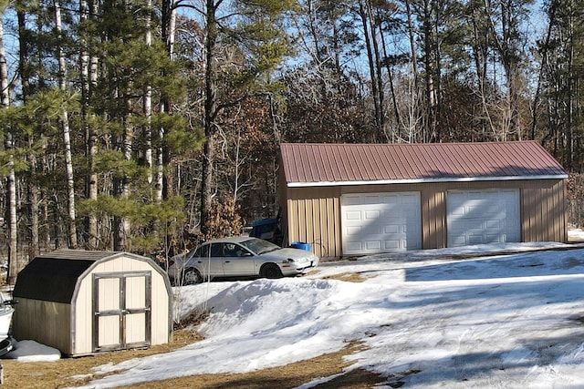 snow covered garage featuring a detached garage