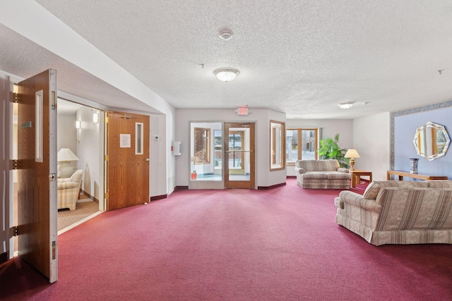 carpeted living room featuring french doors and a textured ceiling