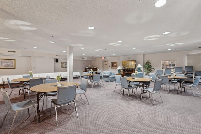 dining space featuring carpet and a textured ceiling