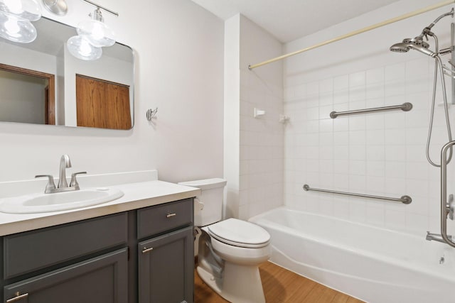 full bathroom with shower / bath combination, wood finished floors, vanity, and toilet