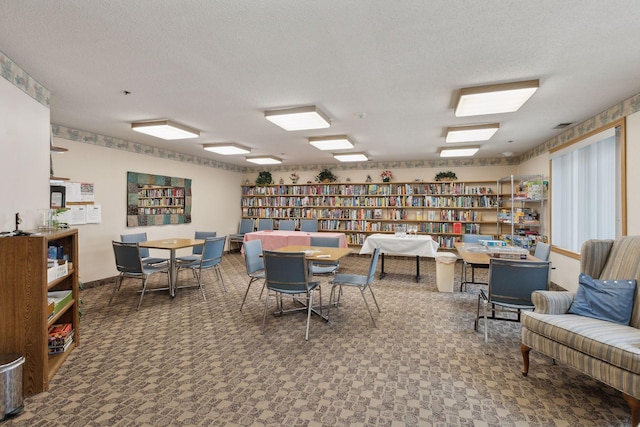 interior space with wall of books and a textured ceiling
